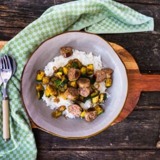 Zucchini mit Reis und würzigen Bratwürsten